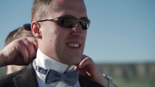 A young man puts on blue bow tie — Stock Video