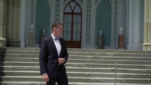 Young man in suit waiting, staying and posing in a city. — Stock Video