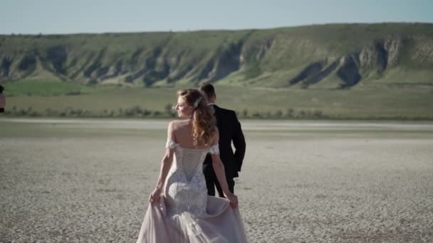 Videograph shooting video with steadicam. Young beautiful bride in a wedding dress goes to the groom. Meeting of the newlyweds. — Stock Video