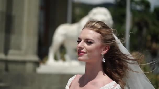 Mladá nevěsta pózuje v městě. Vlající závoj na windy letní den. — Stock video