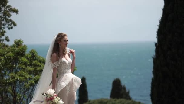 Молода красива наречена в весільній сукні і обнімає нареченого і цілує — стокове відео