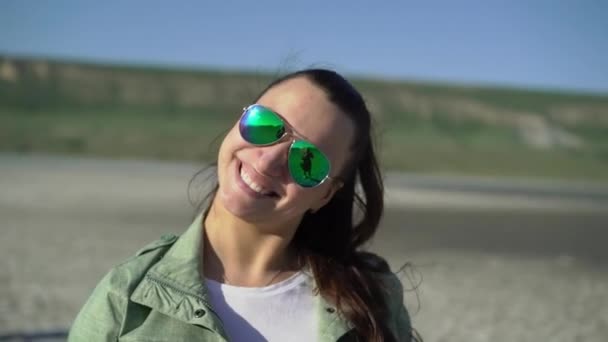 Mujer joven en gafas de sol verdes sonriendo — Vídeos de Stock