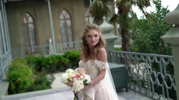 Young bride posing in a city. Waving veil at windy summer day. — Stock Video