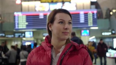 Güzel genç turist kız uçuş bilgi yönetim kurulu bir salonda yakınındaki Uluslararası Havaalanı ya da tren istasyonunda