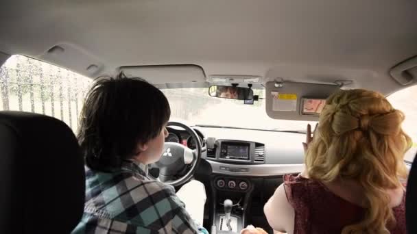 Sankt-Petersburg, Ryssland-den 10 juli 2012: Unga vackra paret i bil. Ha kul och dansa — Stockvideo