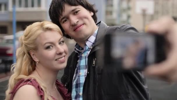 Casal jovem tirando selfie no telefone celular se divertindo na rua — Vídeo de Stock