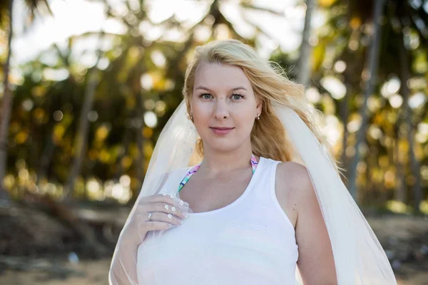 Seksi sarışın genç kadın beyaz elbise ve gelin peçe