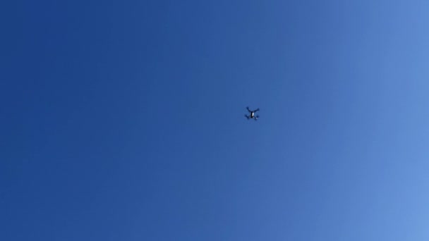 Malá Kvadrokoptéra droneflying na slunečný den. Modrá obloha — Stock video