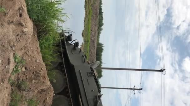 垂直方向のビデオ。曇りの日での砂と池で運転しているタンク — ストック動画