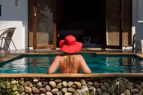 Yüzme havuzunda güneş gözlüklü sarışın genç güzel kadın