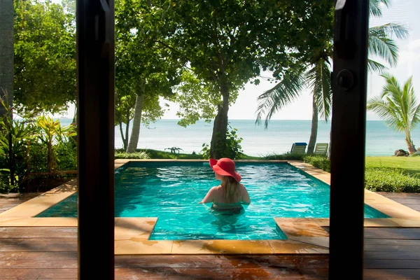 Yüzme havuzunda güneş gözlüklü sarışın genç güzel kadın