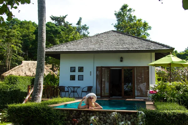 Yüzme havuzunda güneş gözlüklü sarışın genç güzel kadın