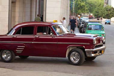 Havana, Küba - 23 Aralık 2011: Retro tarzı taksi araba içinde bir sokak.