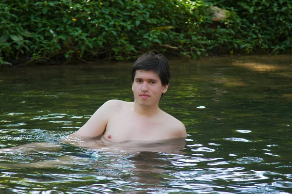 Young man swimming in river