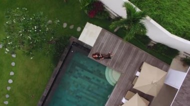 Siyah iç çamaşırı havuzu lüks villasında döşeme genç seksi kadın