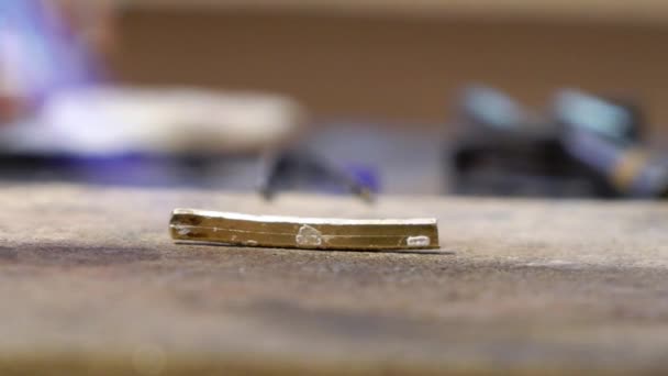 Orfèvre travaillant avec une bague inachevée en utilisant le feu 