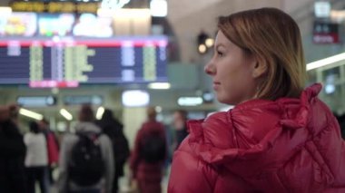 Güzel genç turist kız Uluslararası Havaalanı veya tren garının uçuş bilgi yönetim kurulu