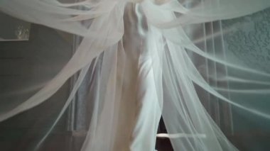 Gelinlik uzun sallama peçe ile gelin gelir ve odaya perdeler açar