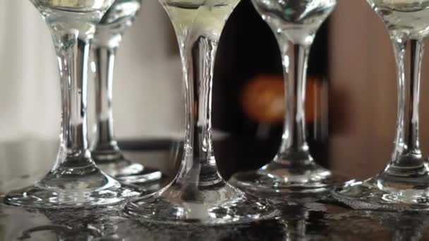 Champagner aus Flasche in leere Gläser am Tisch gießen — Stockvideo
