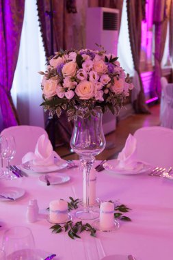 Çatal bıçakla süslenmiş ziyafet masası. Şölen salonunda düğün dekorasyonu. Bayram masası, tabak, peçete, bıçak, çatal. Masa dekorasyonu. Romantik yemek ya da diğer etkinlikler - düğün