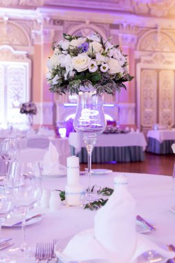 Çatal bıçakla süslenmiş ziyafet masası. Şölen salonunda düğün dekorasyonu. Bayram masası, tabak, peçete, bıçak, çatal. Masa dekorasyonu. Romantik yemek ya da diğer etkinlikler - düğün