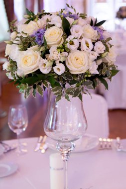 Çatal bıçakla süslenmiş ziyafet masası. Şölen salonunda düğün dekorasyonu. Bayram masası, tabak, peçete, bıçak, çatal. Masa dekorasyonu. Romantik yemek ya da diğer etkinlikler - düğün