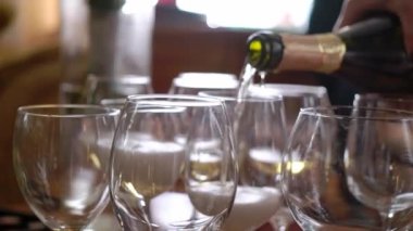 Şişeden boş bardaklara masada şampanya dökmek