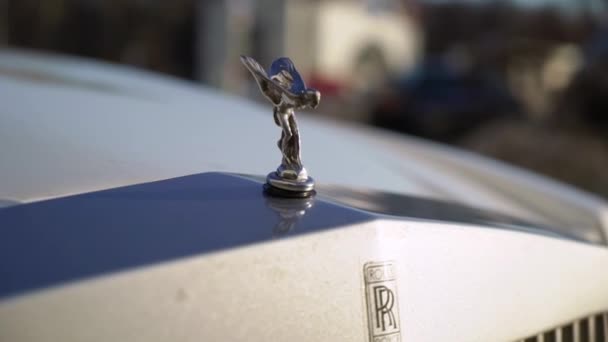 MOSCOW, RÚSSIA - FEVEREIRO 16, 2019: Rolls Royce logo no capô do carro branco no dia ensolarado ao ar livre em uma cidade — Vídeo de Stock