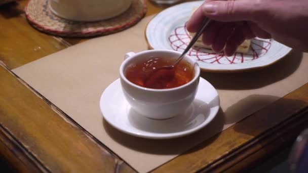 Pouring tea to cup from teapot