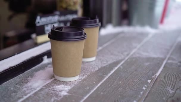 Par att köpa koppar te eller kaffe eller andra varma drycker utomhus på vintern — Stockvideo