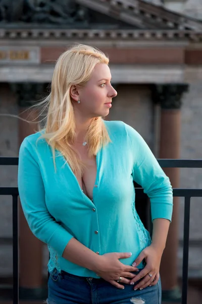 Balkon açık havada günbatımında poz seksi sarışın genç kadın