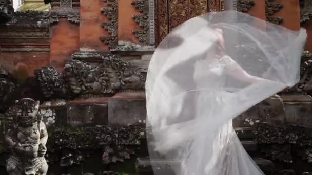 Bela noiva posando perto do templo budista em Bali. A passar por aqui. Casamento romântico . — Vídeo de Stock
