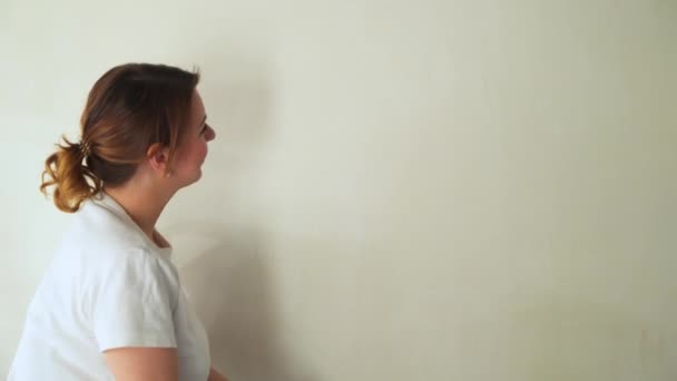 Two girls at construction site glues wallpaper to the wall — 图库视频影像