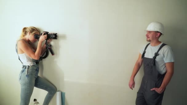 Woman taking photos of worker at construction site renovating flat. — Stock Video