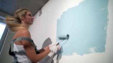 İnşaat alanında boya silindirli genç bir kız müteahhit.