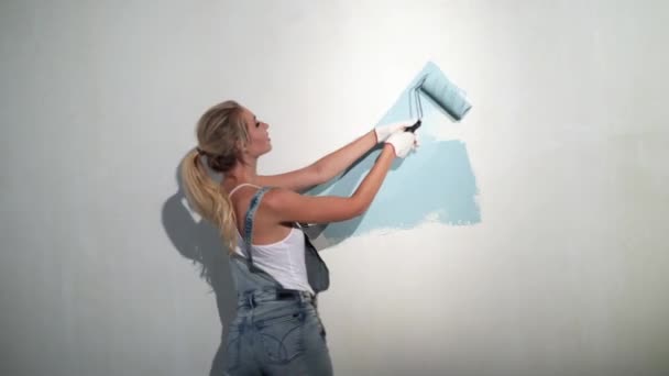 Gadis muda pembangun di lokasi konstruksi dengan rol cat — Stok Video