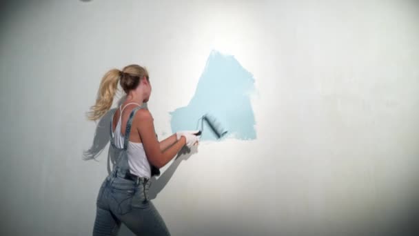 Young girl builder at construction site with paint roller — Stock Video