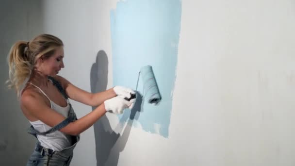 Jovem construtor no local de construção com rolo de pintura — Vídeo de Stock