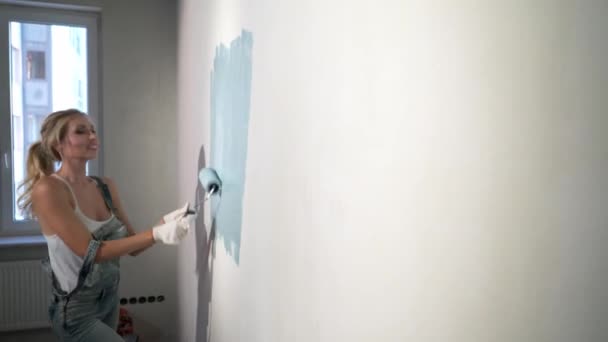 Joven constructora en obra con rodillo de pintura — Vídeos de Stock