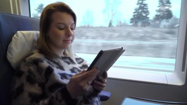 Junge Frau im Eisenbahnwaggon arbeitet mit Tablet — Stockvideo