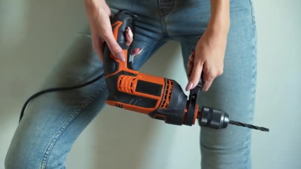 Jeune femme en uniforme travaillant sur chantier, jouant avec une perceuse électrique comme un pistolet — Video