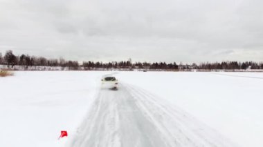 Araba sürücüleri tarafından buzlu yolda kar kış Gölü kapalı. Havadan görünümü. Kışın kar yarış yolda yarış spor araba. Bir yarış arabası sürüş bir karlı yolda.