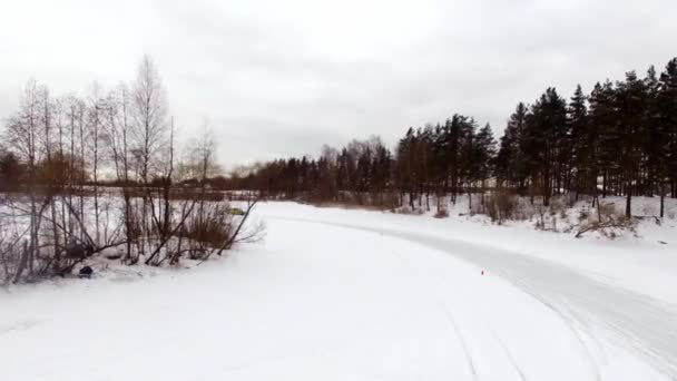 Saint-Petersburg, Rusya Federasyonu-3 Mart 2019: araba sürücüleri tarafından buzlu yolda kar kaplı göl kış. Havadan görünümü. Kışın kar yarış yolda yarış spor araba. Bir yarış arabası sürüş bir karlı yolda. — Stok video