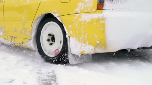 Auto rijdt door ijzige track op sneeuw vallen meer op winter. Sport auto racen op circuit van de sneeuw in de winter. Een raceauto rijden op een besneeuwde weg. — Stockvideo