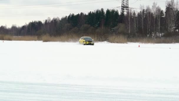 Samochód jeździ lodowatym torem na pokrytym śniegiem jeziorze zimą. Sport wyścigi samochodowe na torze śniegu w zimie. Jazda samochodem wyścigowym na ośnieżonej drodze. — Wideo stockowe