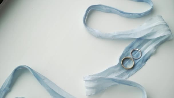 Dos anillos de boda en cinta azul — Vídeos de Stock