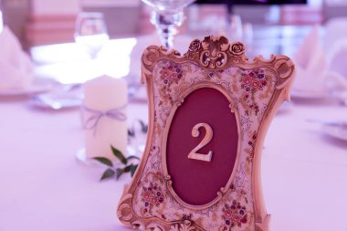 Çatal bıçakla süslenmiş ziyafet masası. Şölen salonunda düğün dekorasyonu. Bayram masası, tabak, peçete, bıçak, çatal. Masa dekorasyonu. Romantik yemek ya da diğer etkinlikler - düğün