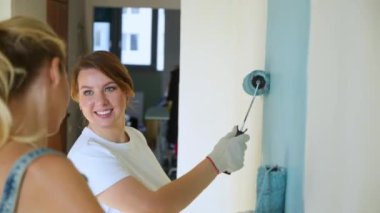 İki kadın işçi silindir daire veya ev duvarlarda boya kullanarak. İnşaat, onarım ve yenileme.