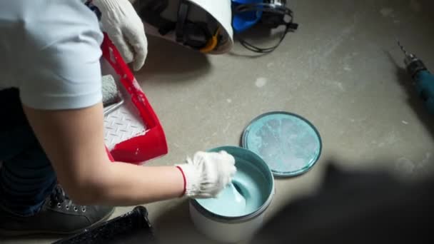 Γυναίκα εργαζόμενος αναμιγνύει χρώμα σε ένα βάζο να βάψετε τους τοίχους σε αυτό το διαμέρισμα ή το σπίτι. Κατασκευή, επισκευή και ανακαίνιση. — Αρχείο Βίντεο