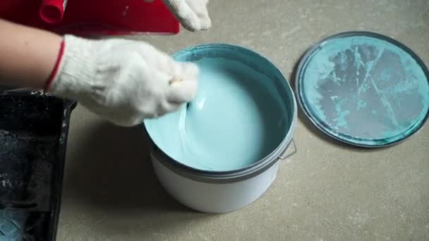 La trabajadora mezcla pintura en un frasco para pintar las paredes del apartamento o casa. Construcción, reparación y renovación . — Vídeo de stock